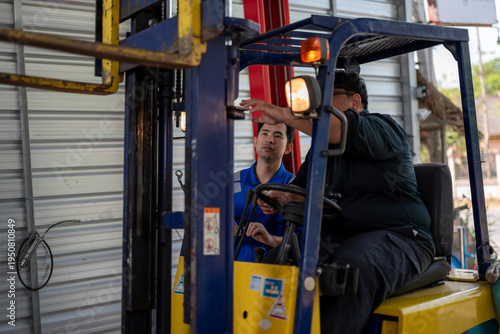 Forklift operator receiving training from technician