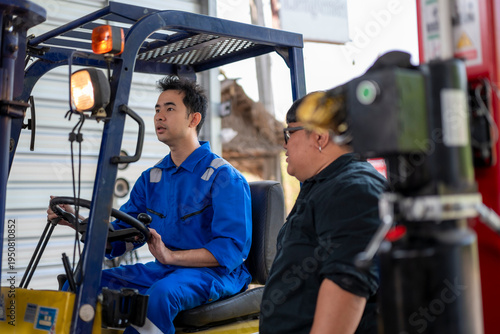 Male workers discussing safety while operating forklift at warehouse