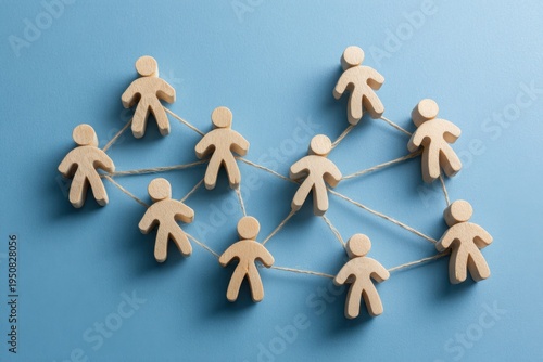 Connected figures: Wooden figurines linked by connecting lines, symbolizing a network, on a vibrant background. Represents concepts like communication, teamwork, and connectivity.
