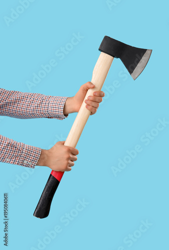 Hands with ax on blue backg...