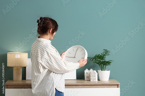 Young woman with clock near...