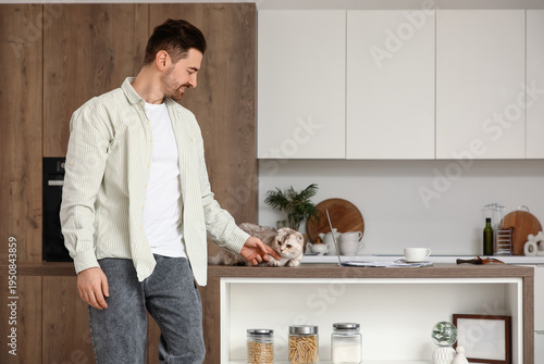 Young man petting cute Scot...