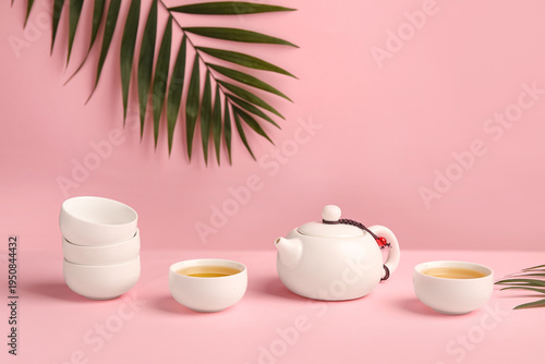 Teapot with cups of tea and...