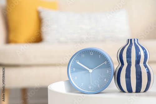 Alarm clock and vase on tab...