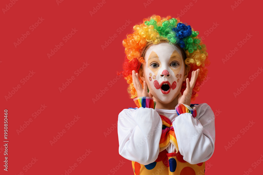 Fototapeta premium Shocked little girl in clown costume on red background. April Fools' Day celebration