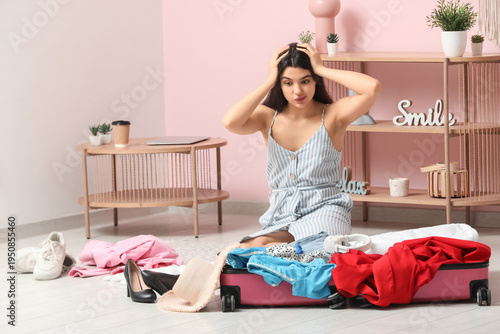 Stressed woman packing suit...