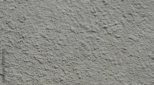 Close-up of rough grey stucco wall with gritty plaster texture, natural construction surface background.