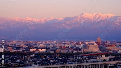 Wallpaper Mural 右へパン　夕景呉羽山からの眺望　茜色に染まる都市市街地ビル群と北アルプス毛勝山～剱岳～立山連峰～薬師岳 Torontodigital.ca
