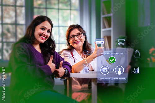 Indian young woman patient and senior lady doctor doing online digital payment successful at medical clinic for digital india concept and financial inclusion while using banking apps