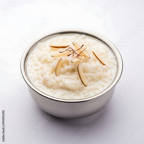 A bowl of creamy rice pudding with saffron and almond slivers on top