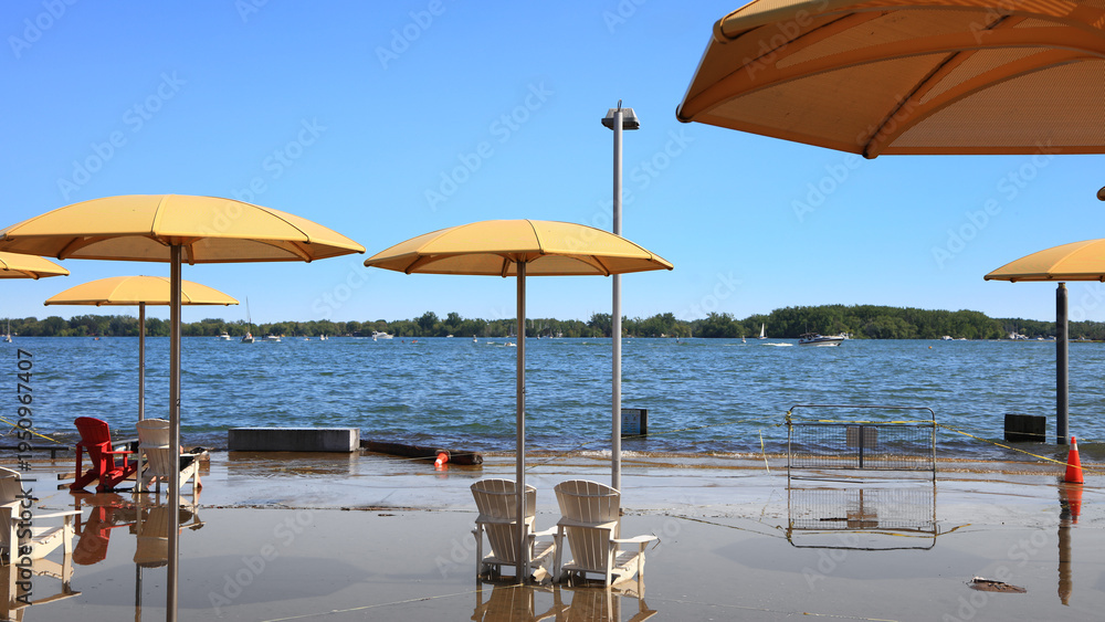 Obraz premium Yellow umbrellas and plastic chairs on Sugar Beach during flood in Toronto.