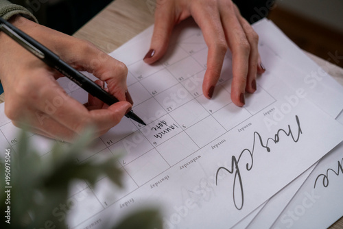 Φωτογραφία Horizontal close-up of entrepreneur writing launch date on paper calendar with p