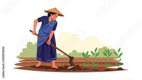Indian female farmer wearing traditional saree and straw hat working in the field with a hoe to tend to green plants.