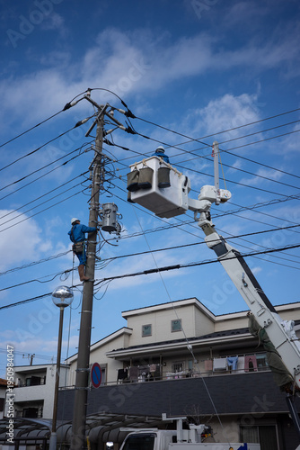 電柱の電気工事をする作業員