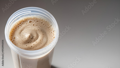 Close-up detailed photography of thick protein shake texture inside a transparent shaker cup with copy space