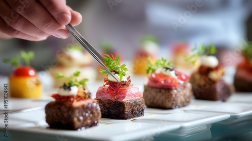 Gourmet food being prepared with tweezers on a plate