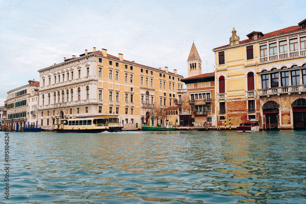Fototapeta premium View of buildings along the water in Venice during daytime with calm clouds overhead