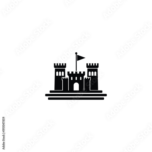 A medieval castle stands on a sandy beach with a flag flying.