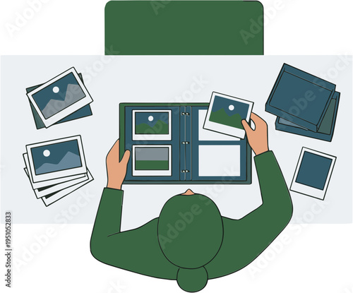 Person arranging photos in album on desk from overhead view