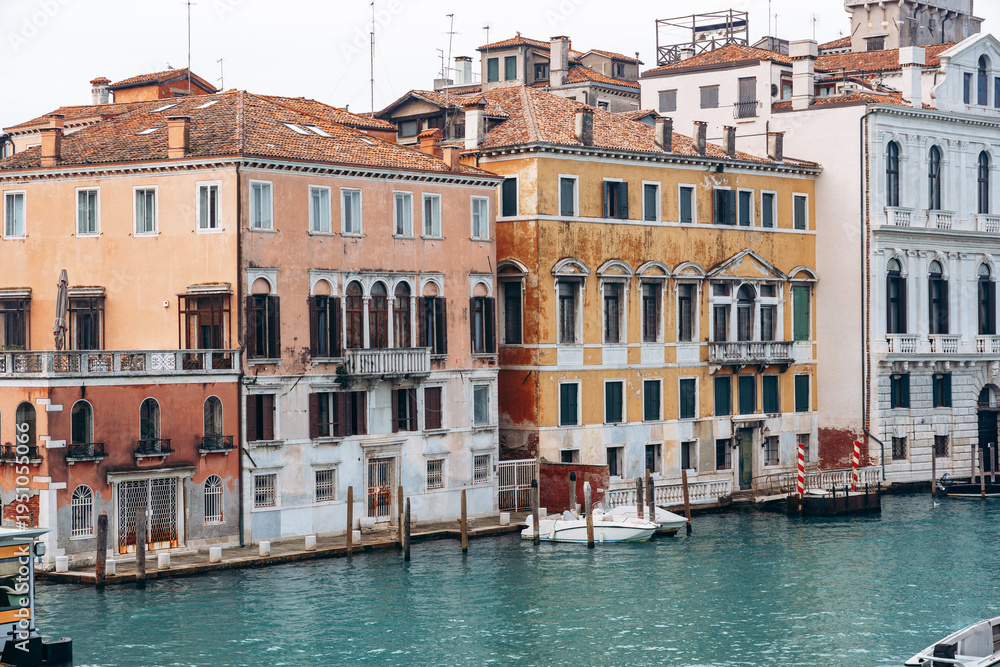 Obraz premium Colorful buildings along a canal in Venice during daytime with clear blue water