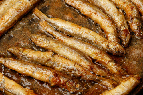 A pan of fish is in a pan of oil