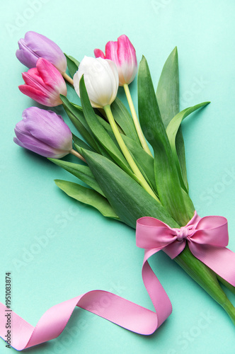 Tulips bouquet with pink ribbon on mint background