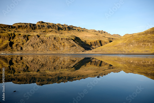 Icy mountain landscape reflecting in still blue water