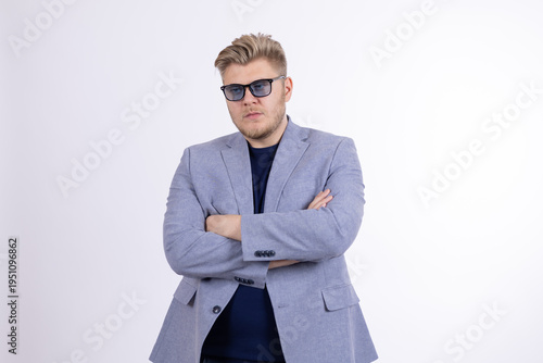 Confident man in sunglasses and jacket with crossed arms