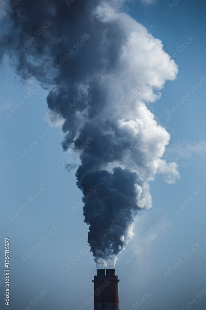 Naklejka premium A haunting view of industrial chimneys spewing black smoke