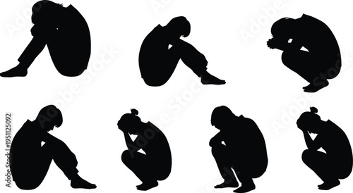 Black silhouettes of people sitting in despair or grief representing sadness mental health loneliness and emotional pain on white,