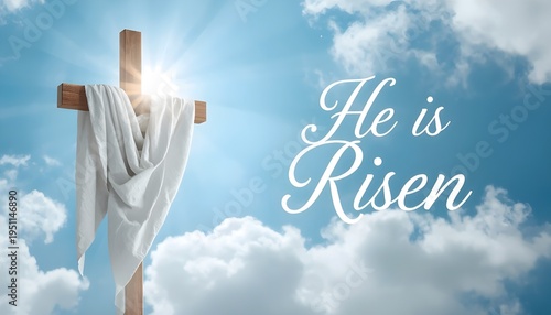 Easter cross with white cloth and he is risen text on sunny blue sky background with clouds