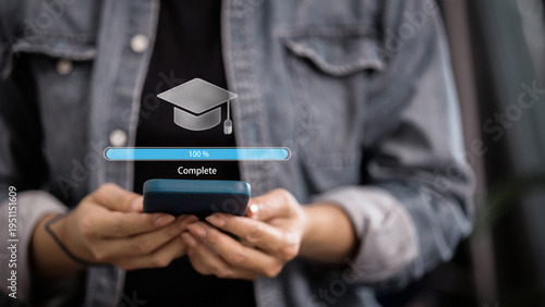 Obraz na płótnie Person holding smartphone with 100 percent complete progress bar and graduation cap icon
