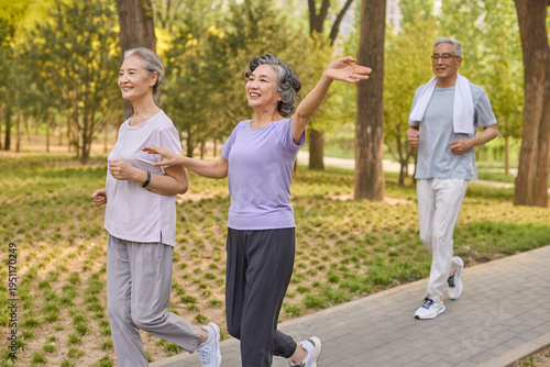 Seniors stroll through the park, enjoying a happy conversation