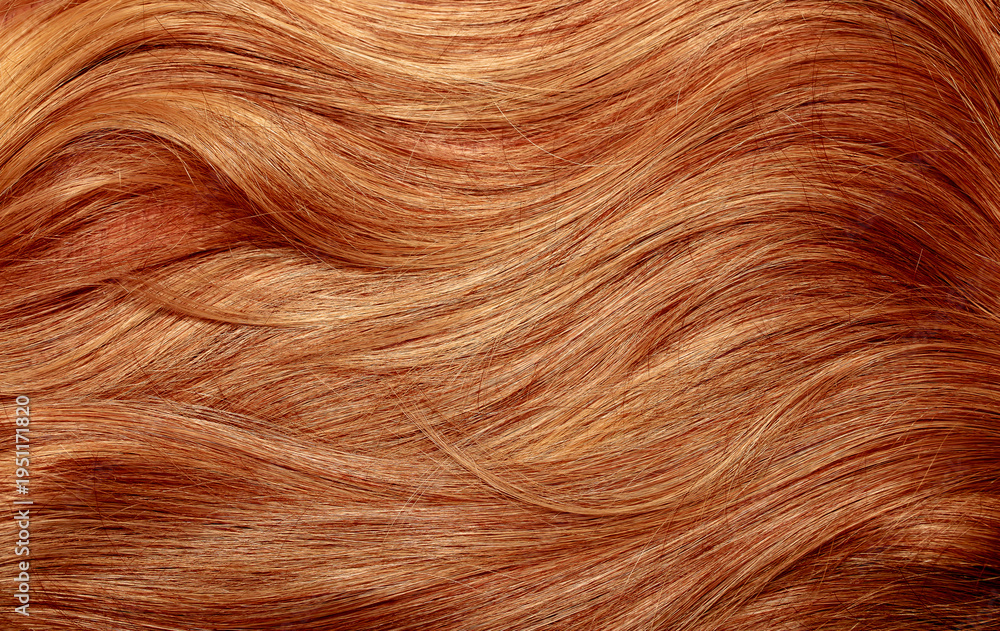 Fototapeta premium Red hair close-up as a background. Women's long orange hair. Beautifully styled wavy shiny curls. Hair coloring bright shades. Hairdressing procedures, extension.