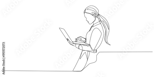 A female office worker uses a laptop while standing