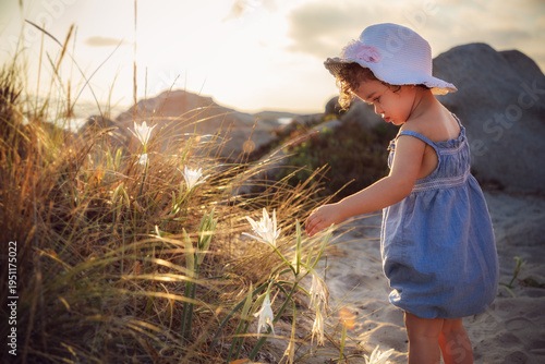 Schilderij op canvas Bambina sulla spiaggia di bassa trinita a la maddalena illuminata dalla luce del
