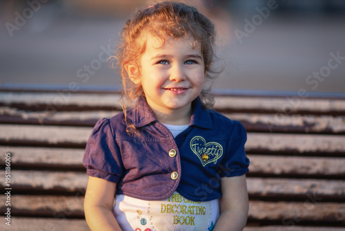 Canvas Print Ritratto a bambina bionda con occhi azzurri illuminata dalla luce calda del tram