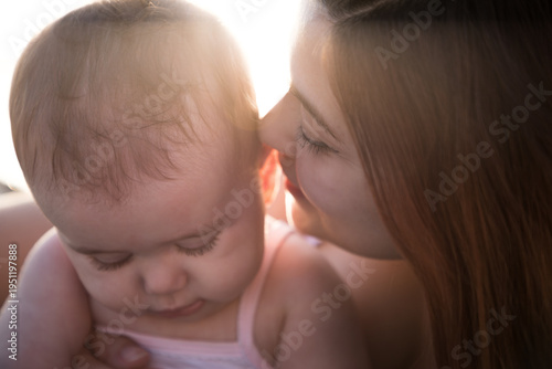 Quadro su tela Primo piano di una madre che bacia teneramente la testa della sua bambina piccol