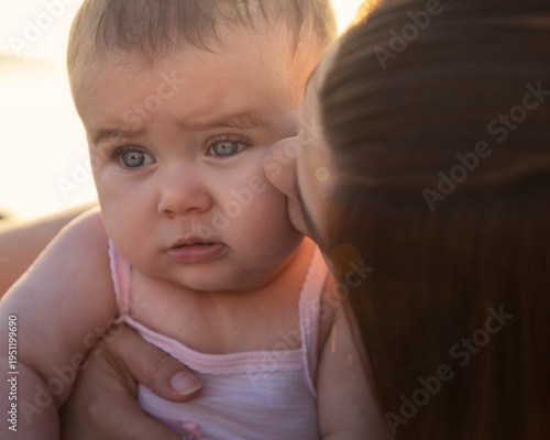 Foto Primo piano di una madre che bacia teneramente la testa della sua bambina piccol