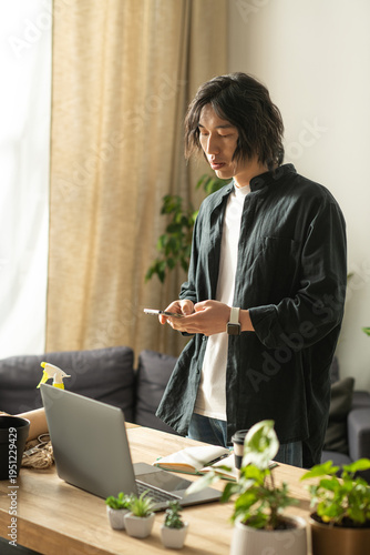 Quadro su tela Young asian florist curating beautiful arrangements in a cozy home workspace