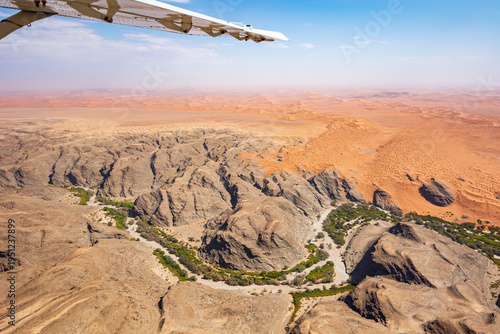 View from a Cessna airplane showing part of the wing and the vast Namib Desert below