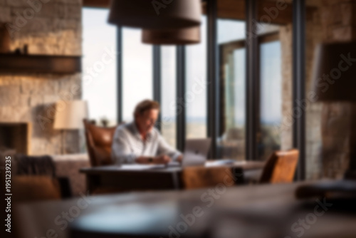 Blurred Businessman working diligently at modern office desk with laptop and papers
