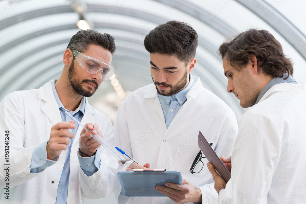 Fototapeta premium three men in labcoats in discussion