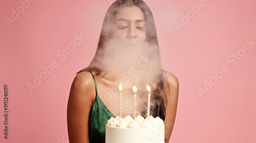 Young Woman Blowing Out Birthday Candles on Cake With a Smile
