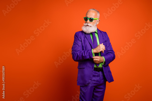 Cuadro en lienzo Dapper elderly man in a bright purple suit with green shirt and tie poses confid