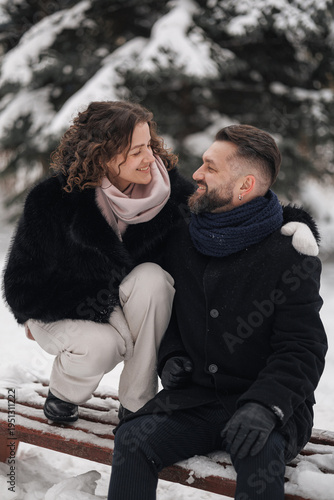 Cuadro en lienzo Happy couple in love embracing and looking at each other in snowy winter park