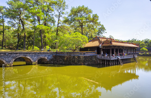 Title Traditional Vietnamese Pavilion and calm lake in a Hue Imperial Tomb park