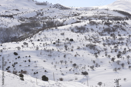 a vast rolling mountain landscape completely blanketed in a thick layer of white snow 