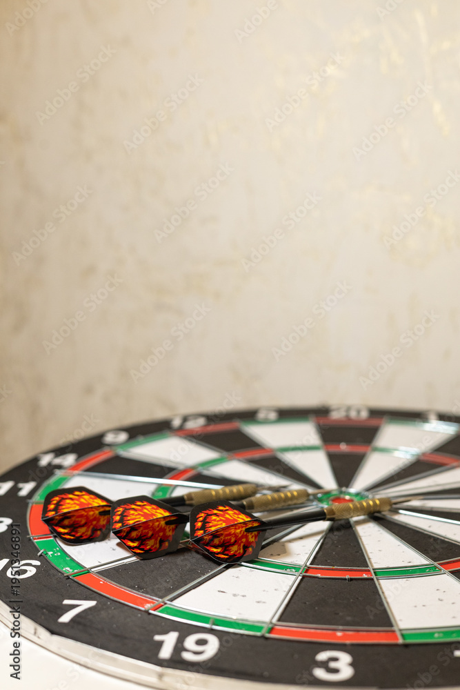 Obraz premium Three Darts Hitting Target on Classic Dartboard with Blurred Background