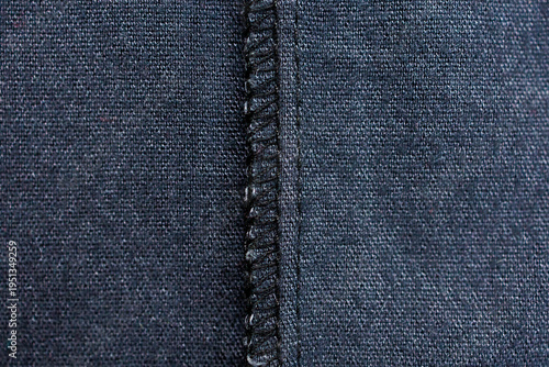 Overlock seam detail on dark fabric inside garment close up